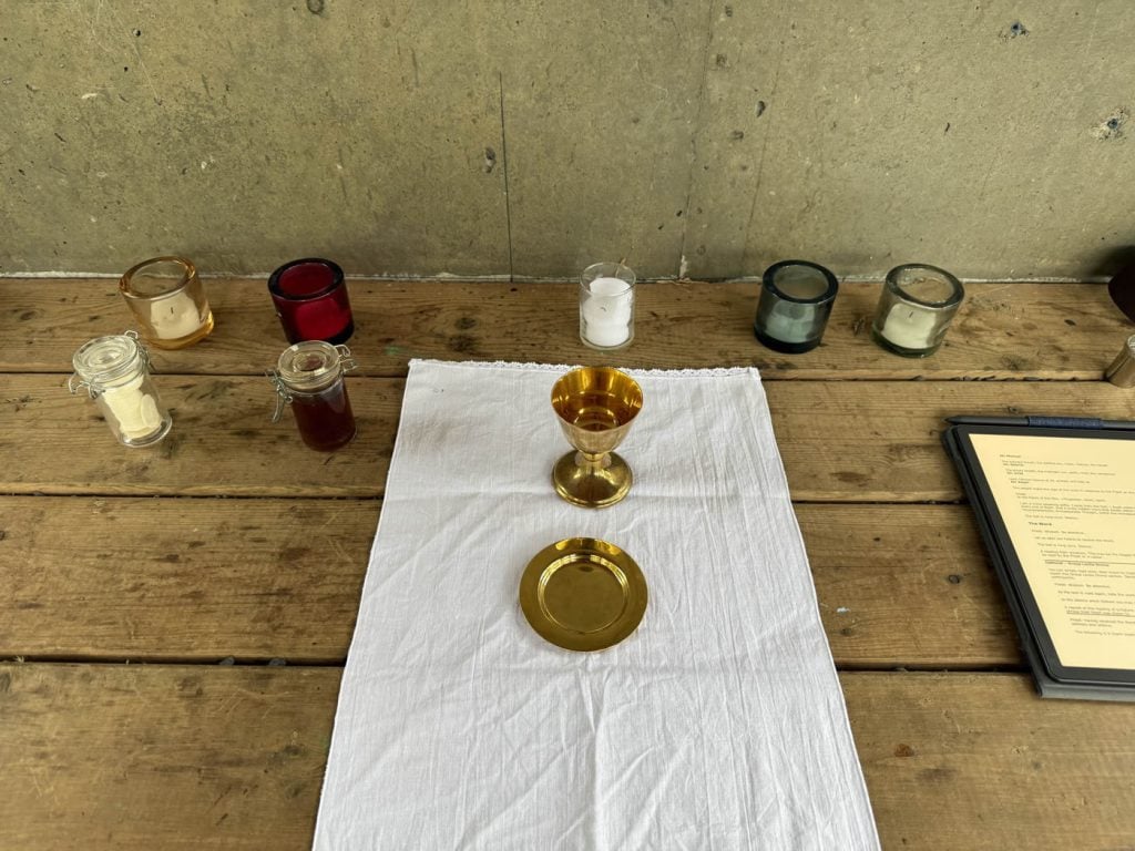 Chalice, paten, and candles arranged on the altar for Mass.