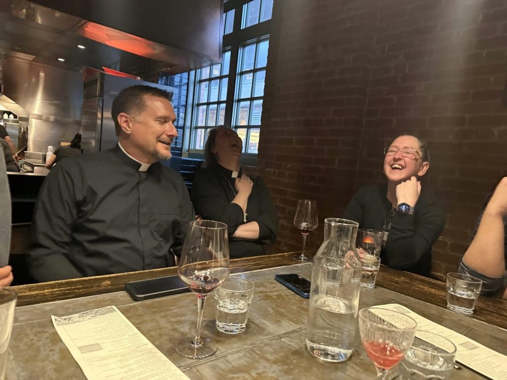 Parish clergy and members sharing a meal together.