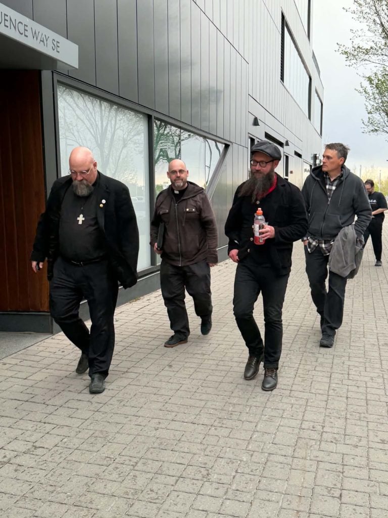 Parish clergy walking together outside a gathering venue.