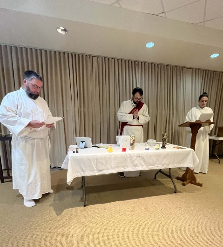 Parish clergy celebrating the Johannite Gnostic Mass at a candlelit altar.